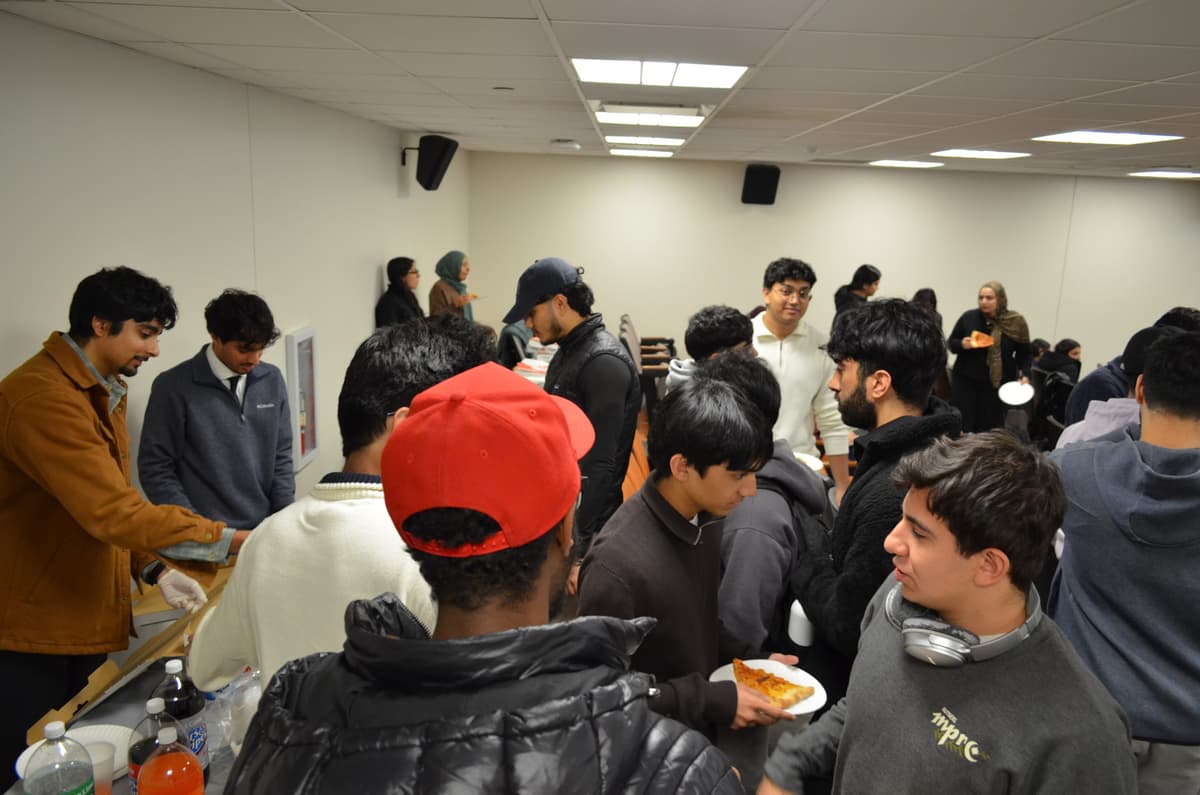 Packed room as students grab pizza and network after the presentations